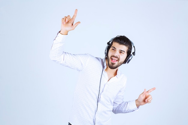 Homme portant des écouteurs et écoutant de la musique.