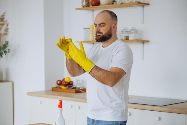 Homme portant des gants en caoutchouc nettoyant à la cuisine