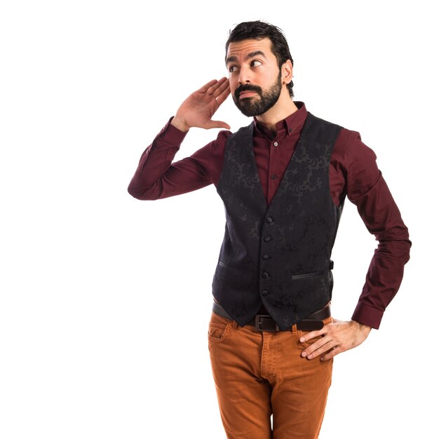 Homme portant un gilet écoutant quelque chose