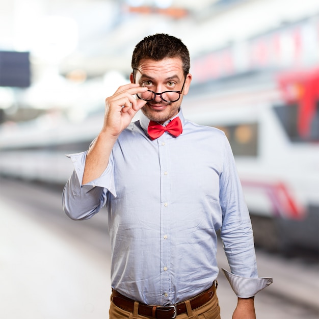 Homme portant un noeud papillon rouge. Donnant sur des lunettes.