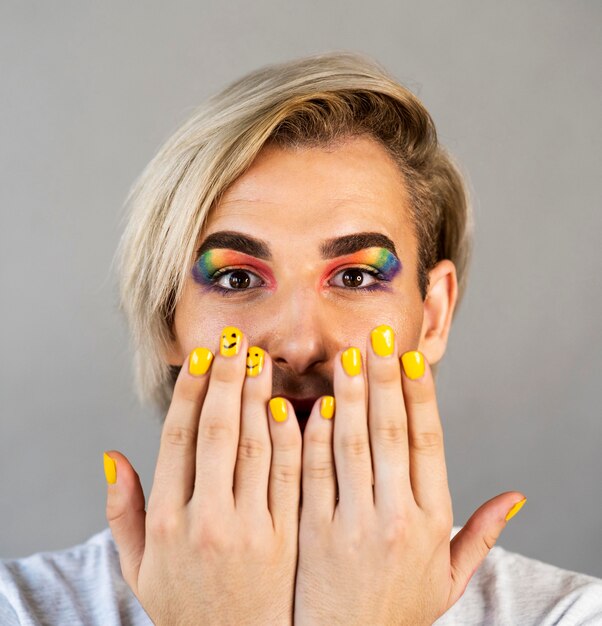 Homme portant des produits de maquillage et de vernis à ongles close-up