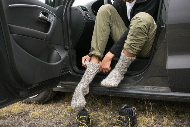 L'homme porte de nouvelles chaussettes sèches fraîches après la randonnée
