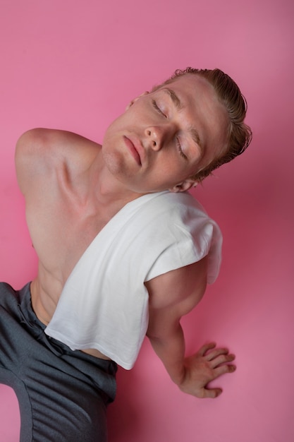 Homme posant avec un angle élevé de fond rose