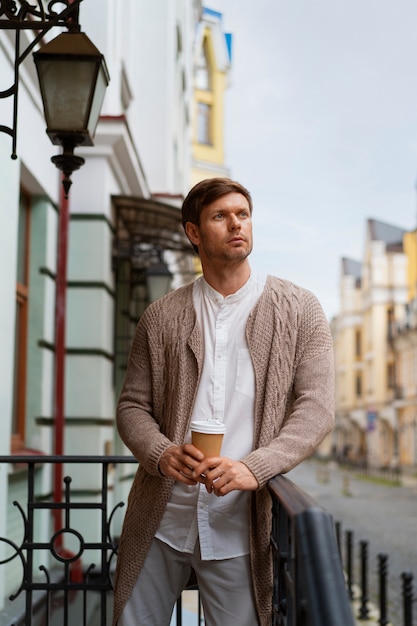 Photo gratuite un homme posant avec un café à emporter