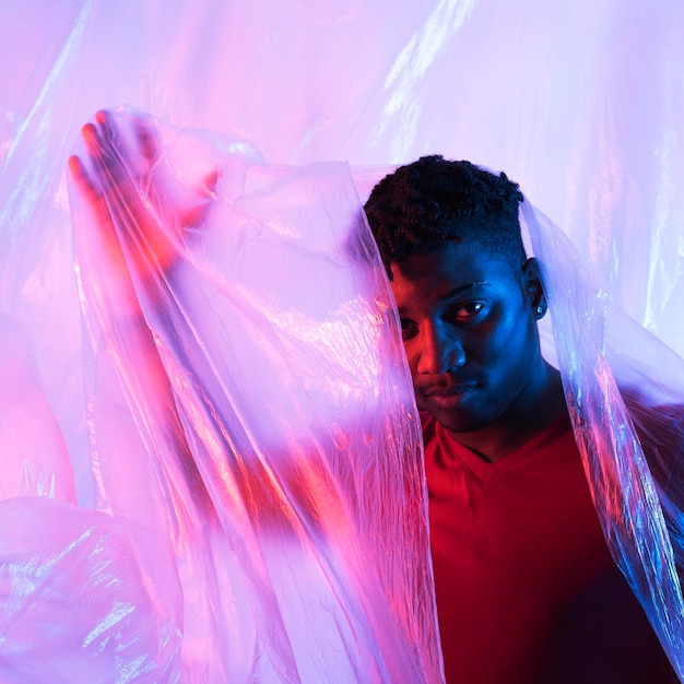 Homme posant avec une feuille de plastique