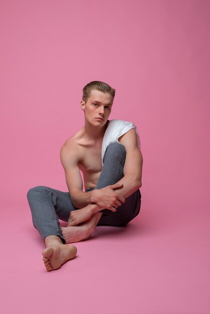 Homme posant avec un fond rose plein coup