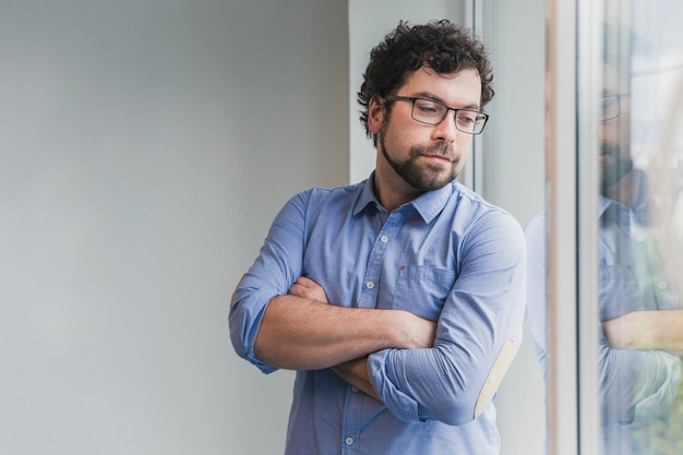 Homme posant près de la fenêtre dans le bureau