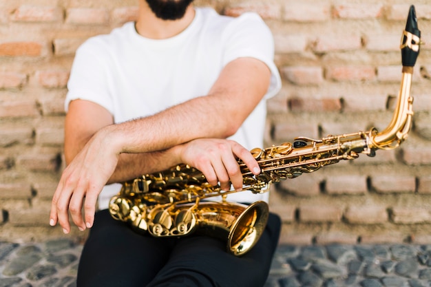 Homme posant avec saxophone dans la rue