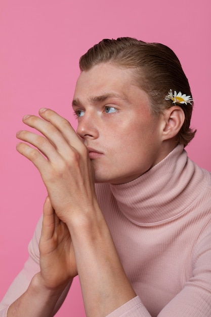 Homme posant avec vue de côté de fleur