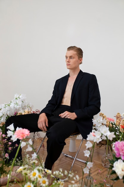 Photo gratuite homme posant avec vue de côté de fleurs