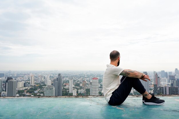 Homme pratiquant le yoga sur le toit