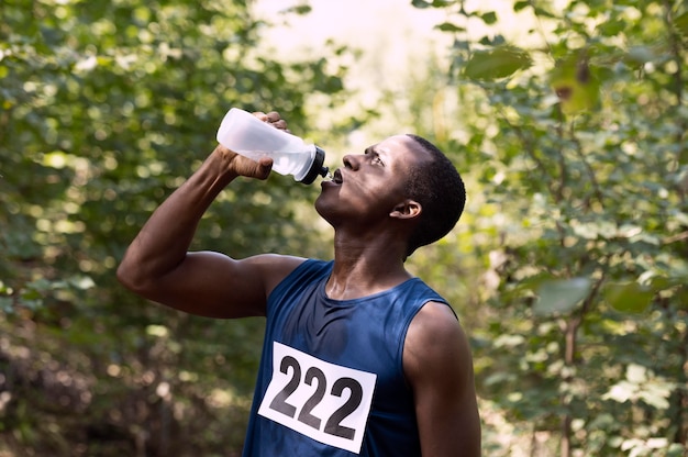 Homme prenant une pause de la course pour boire de l'eau