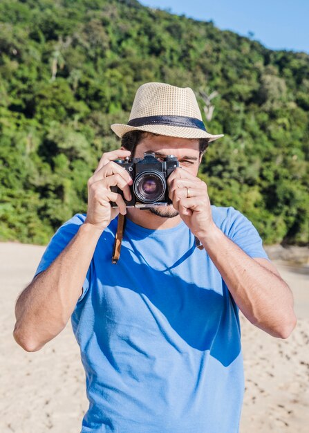 Homme prenant une photo à la plage