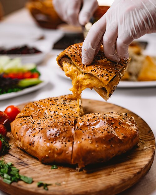 Homme, prend, gâteau viande, sur, planche bois, fromage, vue côté