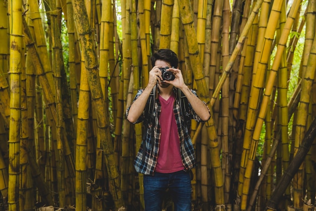 L&#39;homme prend la photo debout devant le bambou
