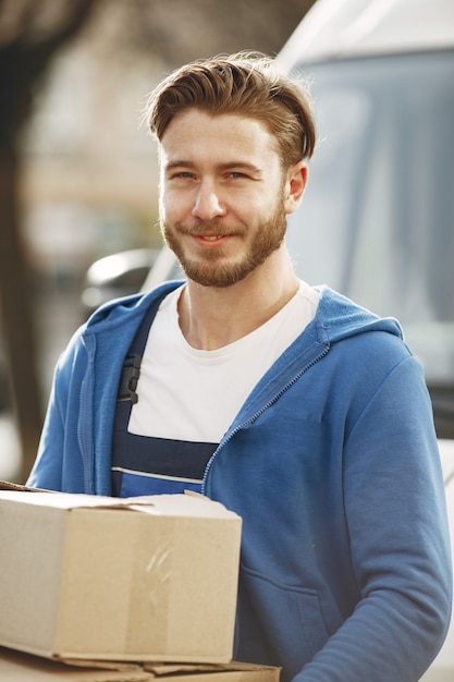 Photo gratuite homme près du camion. guy en uniforme de livraison.