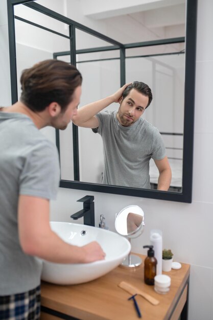 Homme près du miroir se scrutant