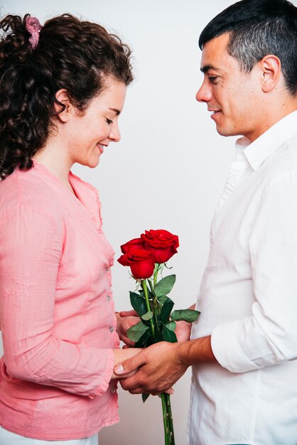 Photo gratuite homme près de jeune femme heureuse avec des fleurs fraîches