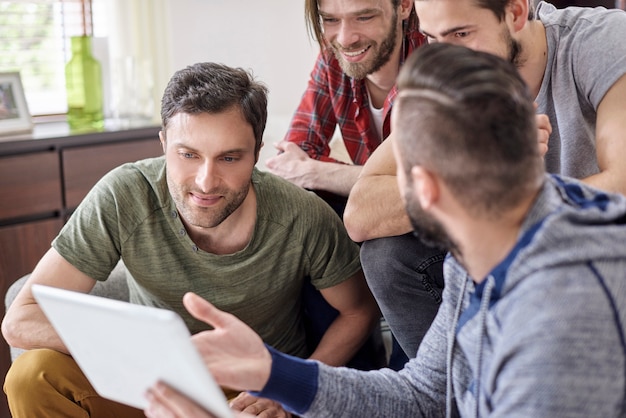 Homme présentant à ses amis sa nouvelle tablette