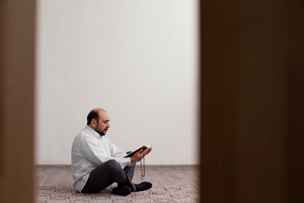 Photo gratuite homme priant sur le sol à l'intérieur