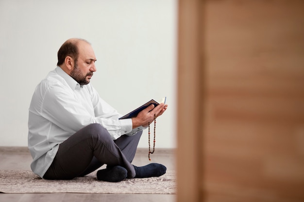 Photo gratuite homme priant sur le sol à l'intérieur