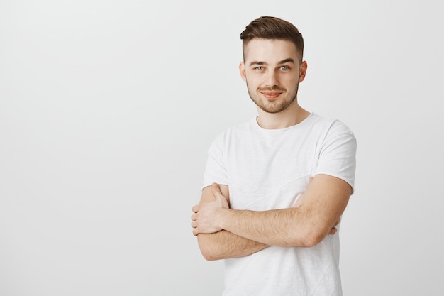 Homme professionnel confiant croise les bras et à la recherche d'un sourire déterminé