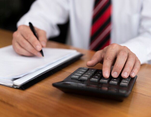 Homme professionnel en tapant des chiffres sur la calculatrice