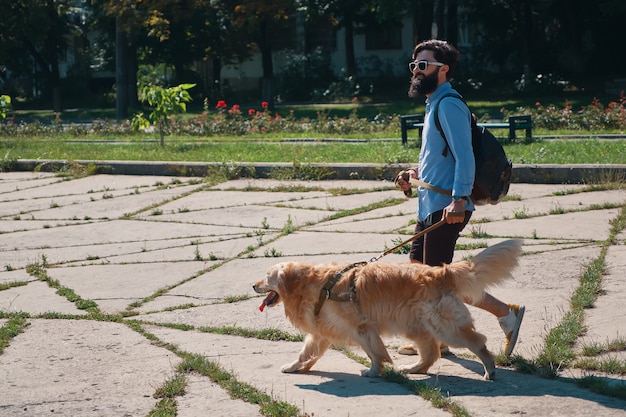 Homme promener son chien dans le parc