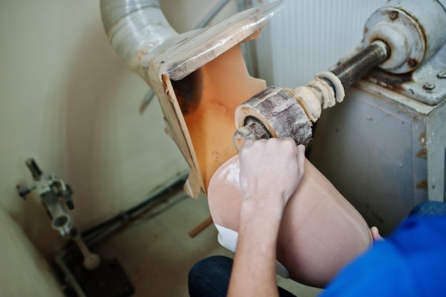 Homme prothésiste fabriquant une jambe prothétique tout en travaillant en laboratoire