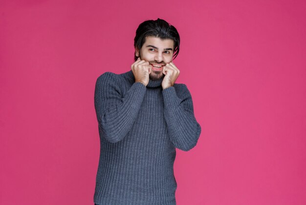 L'homme en pull gris a l'air terrifié et effrayé.