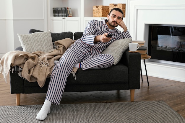 Homme en pyjama devant la télé