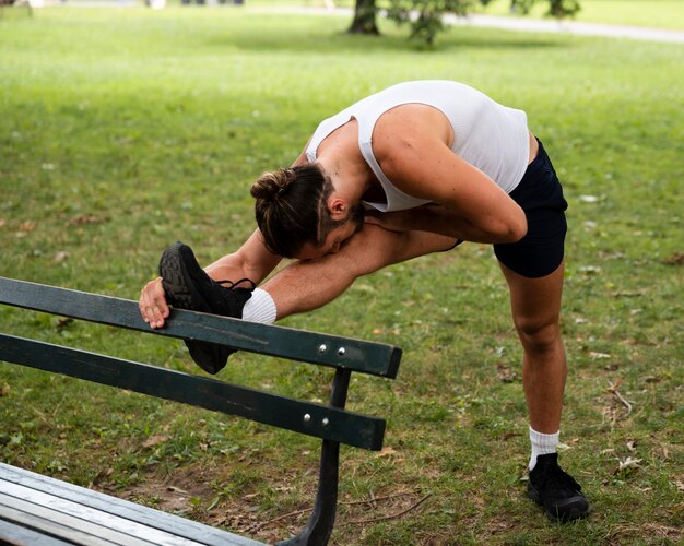 Homme qui s'étend ses jambes dans le parc