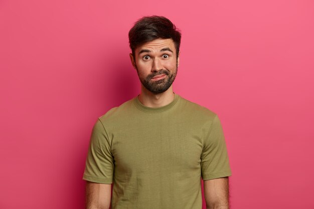 Un homme de race blanche barbu indigné porte les lèvres, regarde avec émerveillement