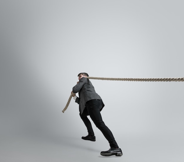 Homme de race blanche en formation de vêtements de bureau isolée sur un mur gris