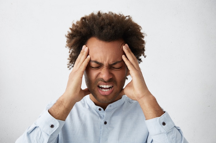 Photo gratuit homme de race mixte a souligné avec tête de cheveux bouclés fronçant son visage tenant les mains sur la tête