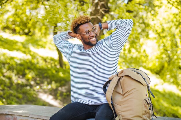 Un homme raffiné posant avec un sac à dos