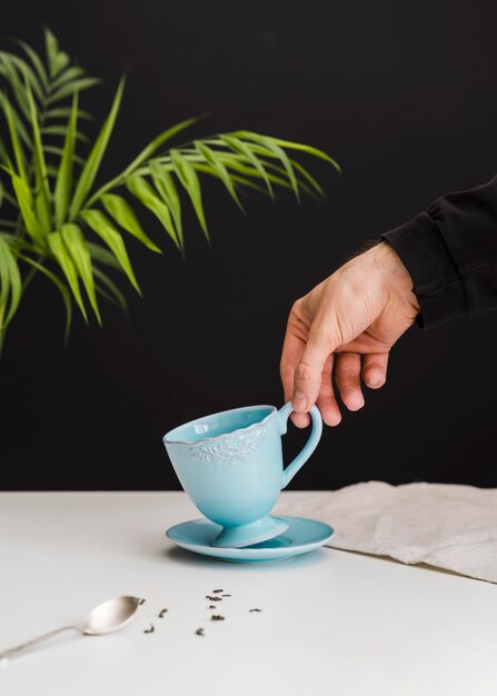 Homme, ramasser, tasse thé