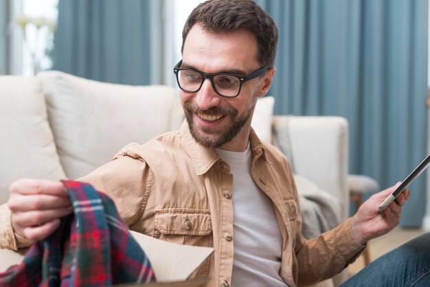 Un homme ravi de l'achat en ligne qu'il a fait