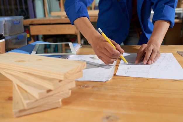 Photo gratuite homme recadré portant des dessins d'ensemble bleus sur la feuille de papier