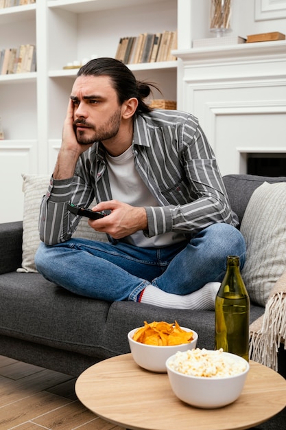 Photo gratuite homme à la recherche d'une chaîne à la télévision