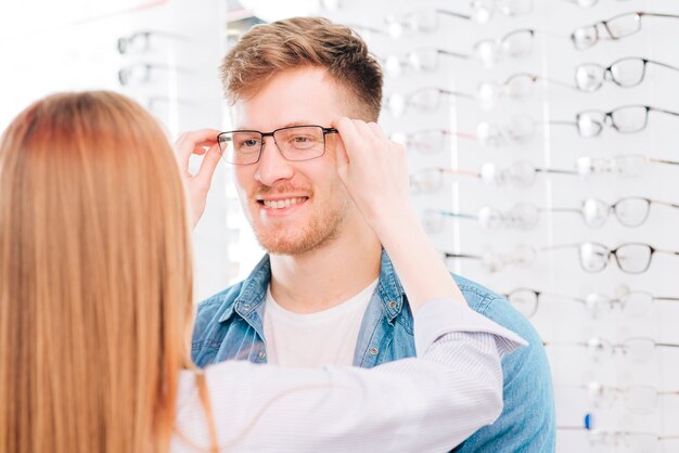 Homme à la recherche de nouvelles lunettes chez l&#39;optométriste