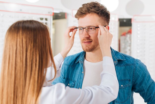 Homme à la recherche de nouvelles lunettes chez l&#39;optométriste