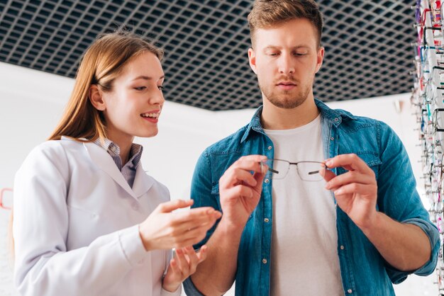 Photo gratuite homme à la recherche de nouvelles lunettes chez l'optométriste