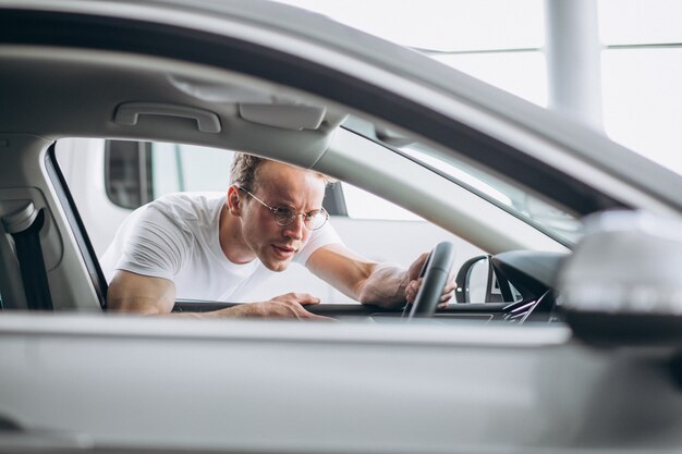 Homme à la recherche d&#39;une voiture dans une salle d&#39;exposition