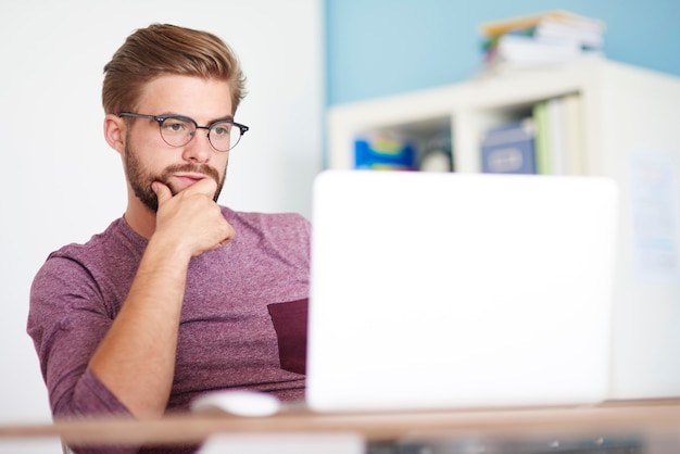 Photo gratuite homme réfléchi devant l'ordinateur