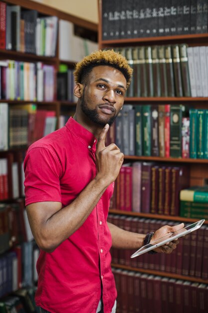 Homme réfléchi posant avec une tablette