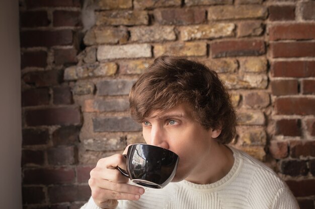 Homme réfléchi prenant un café