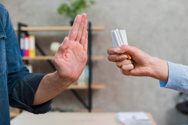 Homme refusant un paquet de cigarettes offert par son amie