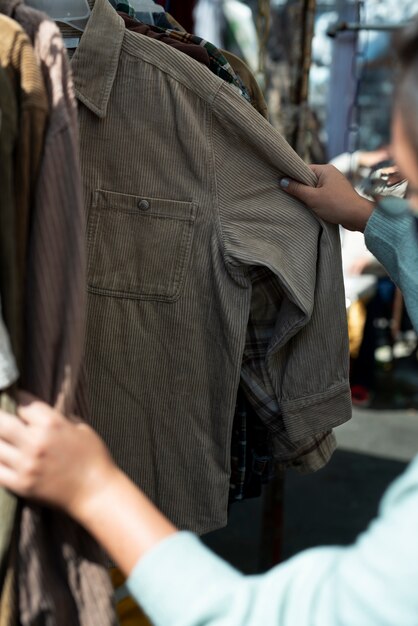 Homme regardant des chemises au marché d'occasion