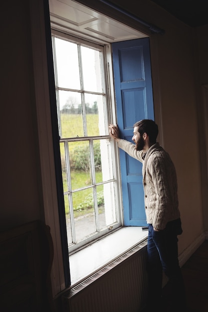 Photo gratuite homme regardant par la fenêtre